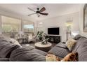 Bright, airy living room features large sectional, ceiling fan, and an abundance of natural light at 805 E La Palta St, Queen Creek, AZ 85140