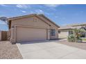 Inviting home featuring a two-car garage and low-maintenance desert landscaping at 8733 W Laurel Ln, Peoria, AZ 85345