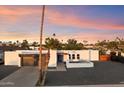Exterior shot of a bright single-story home featuring desert landscaping, a modern garage, and an open patio at 10245 N 34Th Pl, Phoenix, AZ 85028