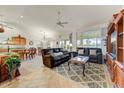 Open living room with neutral tile floors, a ceiling fan, and comfortable seating at 15695 W Earll Dr, Goodyear, AZ 85395