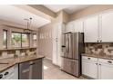 Charming kitchen featuring granite countertops, stainless steel appliances, and mosaic backsplash at 16837 W Northampton Rd, Surprise, AZ 85374