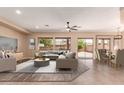 A stylish living room with comfortable seating, a ceiling fan, and natural light from the backyard view at 16837 W Northampton Rd, Surprise, AZ 85374