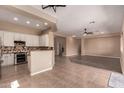 Open-concept living space featuring tile and wood flooring, connecting the kitchen to the living area at 16837 W Northampton Rd, Surprise, AZ 85374