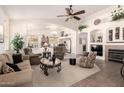 Spacious open-concept living room featuring vaulted ceilings, a fireplace, and seamless flow into the kitchen at 18077 W Sammy Way, Surprise, AZ 85374