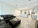 Open-concept living area with kitchen view, sleek sectional sofa, and light, airy feel at 18100 N Piccolo Dr, Maricopa, AZ 85138