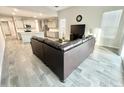 Open-concept living area showcases modern sectional sofa, bright kitchen, and tile flooring at 18100 N Piccolo Dr, Maricopa, AZ 85138