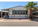 Charming single-story home featuring large windows, a covered carport, and a beautifully landscaped yard with a mature palm tree at 205 S Higley Rd # 300, Mesa, AZ 85206