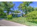 Charming single-story home with lush greenery and a vibrant blue trim, creating a welcoming curb appeal at 220 E 14Th St, Tempe, AZ 85281