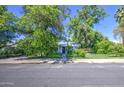 A charming single-story home framed by mature trees, showcasing its inviting curb appeal at 220 E 14Th St, Tempe, AZ 85281