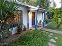 Charming exterior featuring a quaint front porch, lush landscaping, and bright blue accents at 220 E 14Th St, Tempe, AZ 85281
