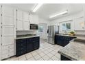Well-lit kitchen features stainless steel appliances, granite countertops, and white tile floors at 2395 S Arizona Rd, Apache Junction, AZ 85119