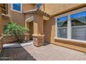 Home exterior with brick-paved patio and small palm trees, showcasing the beautiful architectural details at 3436 E Gary Way, Gilbert, AZ 85234