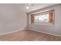 A cozy bedroom with wood-look flooring and a window featuring wooden shutters, providing natural light at 3823 W Berridge Ln, Phoenix, AZ 85019