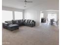 Bright living room featuring neutral walls, plush carpeting, and a comfortable sectional sofa at 44147 W Snow Dr, Maricopa, AZ 85138