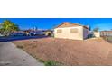 View of the front of the house with a gravel yard, covered parking, and a chain link fence at 4727 N 50Th Dr, Phoenix, AZ 85031