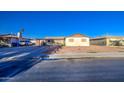 A photograph of the house with a gravel front yard and covered carport, taken from across the street at 4727 N 50Th Dr, Phoenix, AZ 85031