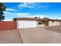 Single-story home with a two-car garage and low-maintenance desert landscaping at 612 N Recker Rd, Mesa, AZ 85205