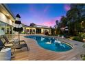 Relax by the pool surrounded by a wood deck, lounge chairs and a view of the pink and blue sunset at 6417 N 52Nd Pl, Paradise Valley, AZ 85253