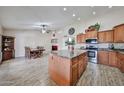 Open kitchen showcasing an island, stainless steel appliances, and seamless flow into the adjacent dining area at 7125 W Canterbury Dr, Peoria, AZ 85345