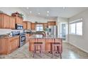 Spacious kitchen featuring a large island, granite countertops, stainless steel appliances, and custom wood cabinetry at 7125 W Canterbury Dr, Peoria, AZ 85345