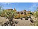 Desert home featuring a wall, tile roof and mature desert landscaping at 9290 E Thompson Peak Pkwy # 409, Scottsdale, AZ 85255