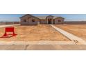Exterior of a one-story tan home with a sidewalk leading to the front door, new construction at 9485 W Sandstone Mountain Dr, Casa Grande, AZ 85194