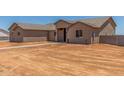 Exterior of a one-story tan home with desert landscaping and blue sky at 9485 W Sandstone Mountain Dr, Casa Grande, AZ 85194
