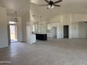 Open-concept living room and kitchen feature vaulted ceilings, stylish lighting, and neutral finishes throughout at 9485 W Sandstone Mountain Dr, Casa Grande, AZ 85194