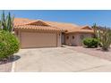 Tan single-story home with desert landscaping and concrete driveway leading to a two car garage at 9802 W Rockwood Dr, Peoria, AZ 85382