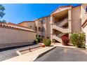 Condominium complex featuring a red tile roof, multiple staircases, and desert landscaping at 10080 E Mountainview Lake Dr # 327, Scottsdale, AZ 85258