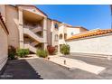 Condominium complex exterior with multiple staircases, beautiful desert landscaping, and red tile roof at 10080 E Mountainview Lake Dr # 327, Scottsdale, AZ 85258