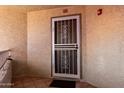 Apartment 327 entrance featuring a white security door, neutral paint, and outdoor patio at 10080 E Mountainview Lake Dr # 327, Scottsdale, AZ 85258
