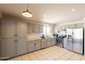 Well-equipped kitchen with gray cabinets, stainless steel appliances, and granite countertops at 12208 N 41St Ln, Phoenix, AZ 85029