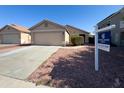 Inviting home featuring a well-maintained front yard, two-car garage, and professional real estate signage at 12934 W Voltaire Ave, El Mirage, AZ 85335
