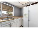 Functional kitchen featuring ample counter space, white appliances, and a window with backyard view at 1407 W Utopia Rd, Phoenix, AZ 85027
