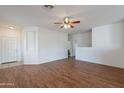 Inviting living room with wood flooring, a ceiling fan, and bright natural light at 14244 N 132Nd Ln, Surprise, AZ 85379