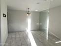 Bright living room with stylish tile flooring, modern light fixture, and ample natural light at 14300 W Bell Rd # 57, Surprise, AZ 85374