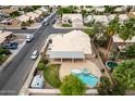 Aerial view of home featuring backyard pool, spa, covered patio, lush yard, mature trees and convenient neighborhood access at 1523 E Tulsa St, Chandler, AZ 85225