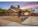 Exterior elevation featuring a well-maintained yard, 3-car garage, and inviting desert rock landscaping at 1523 E Tulsa St, Chandler, AZ 85225