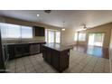 Spacious kitchen with granite countertops, an island, and ample cabinet space at 15642 N Naegel Dr, Surprise, AZ 85374