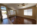 Bright living room featuring wood floors, large windows, and a ceiling fan at 15642 N Naegel Dr, Surprise, AZ 85374