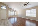 Bright living room with wood floors, ceiling fan, and multiple windows with natural light at 15642 N Naegel Dr, Surprise, AZ 85374
