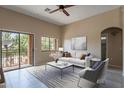Bright living room with tile flooring, slider to balcony, ceiling fan, and a modern minimalist decor at 18250 N 32Nd St, Phoenix, AZ 85032