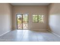 Neutral living room with tile flooring, a glass door to the balcony and a view of the outdoors at 18250 N 32Nd St, Phoenix, AZ 85032