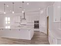 This bright kitchen features white cabinets, stainless steel appliances, a subway tile backsplash, and a large island at 20274 W Monterey Way, Buckeye, AZ 85396