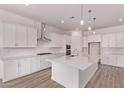 Bright kitchen with white cabinets, stainless steel appliances, large island, and wood-look flooring at 20274 W Monterey Way, Buckeye, AZ 85396