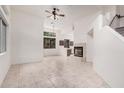 Bright living room showcasing neutral tile floors, fireplace, ceiling fan and view into the kitchen at 2308 S Bernard --, Mesa, AZ 85209