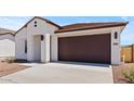 Charming single-story home featuring a two-car garage, desert landscaping, and a modern facade at 23443 W Albeniz Pl, Buckeye, AZ 85326
