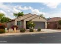 View of this tan home showing the front yard and side yard featuring desert landscaping at 25028 W Wayland Dr, Buckeye, AZ 85326