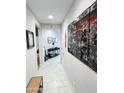 Inviting hallway featuring decorative artwork and neutral tile flooring at 25028 W Wayland Dr, Buckeye, AZ 85326